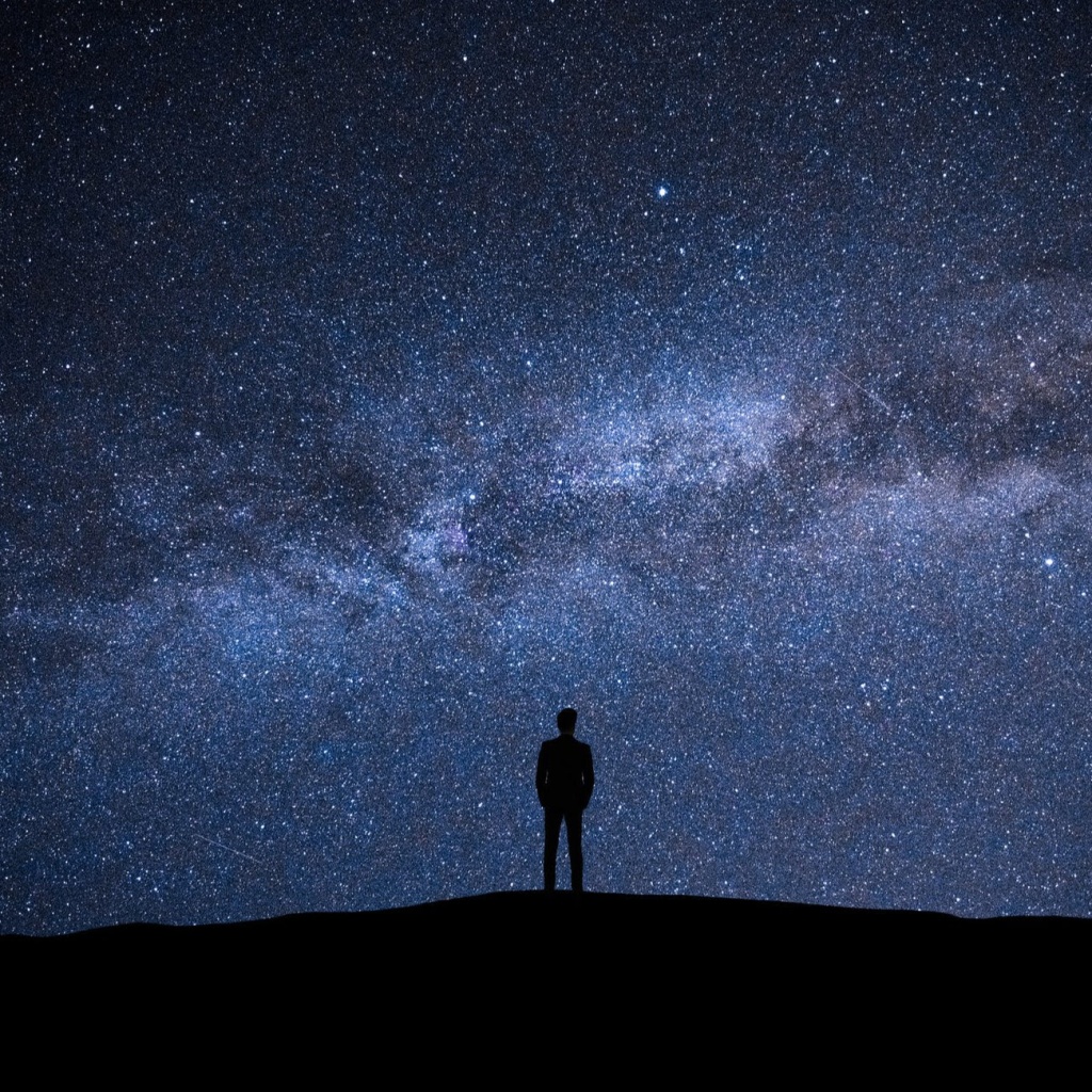 Sky and stars with a silhouette of a man in the dark
